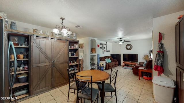 dining space with a textured ceiling, ceiling fan with notable chandelier, light tile patterned flooring, and visible vents