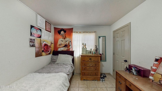 bedroom with light tile patterned floors and a textured ceiling