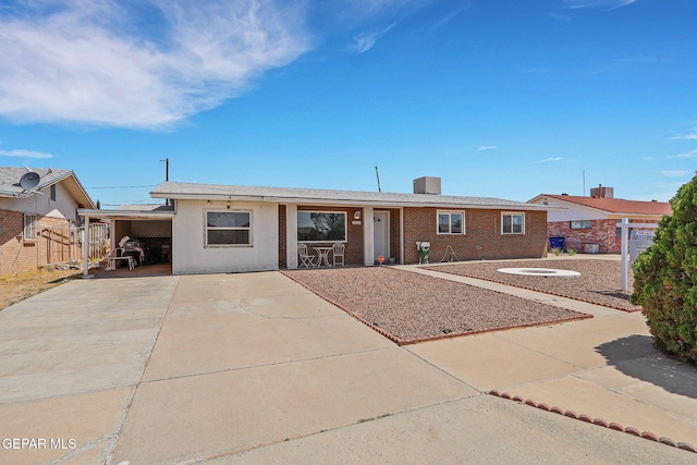 ranch-style home featuring concrete driveway and an attached carport