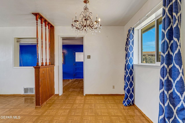 interior space with a chandelier, visible vents, and baseboards