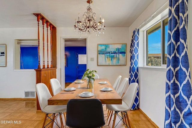 dining room with a notable chandelier, baseboards, and visible vents