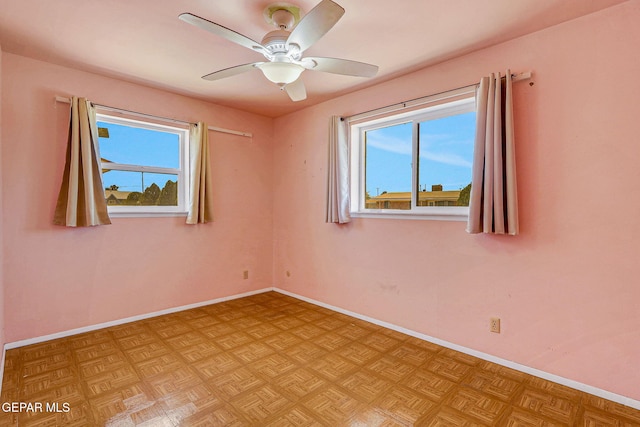 unfurnished room with ceiling fan and baseboards