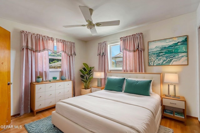bedroom with ceiling fan, light wood-type flooring, and baseboards