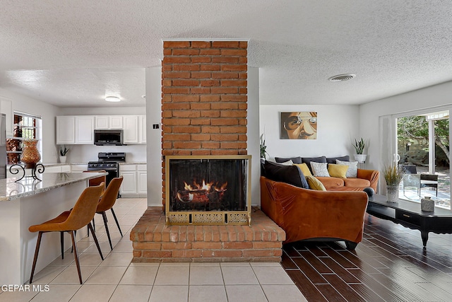 3705 Roslyn Dr, Horizon City, TX 79928 - living area with a textured ceiling, a brick fireplace, and visible vents