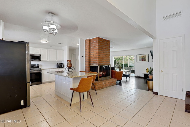 3705 Roslyn Dr, Horizon City, TX 79928 - kitchen featuring a breakfast bar area, light tile patterned floors, visible vents, open floor plan, and stainless steel appliances