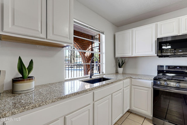 3705 Roslyn Dr, Horizon City, TX 79928 - kitchen featuring a sink, light tile patterned flooring, white cabinets, and appliances with stainless steel finishes