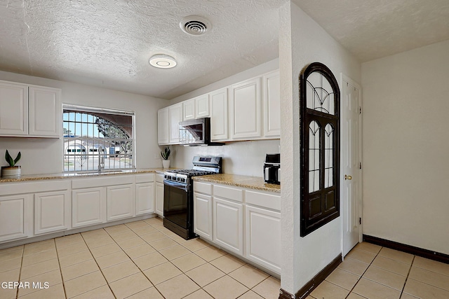 3705 Roslyn Dr, Horizon City, TX 79928 - kitchen with light countertops, appliances with stainless steel finishes, light tile patterned floors, and white cabinetry