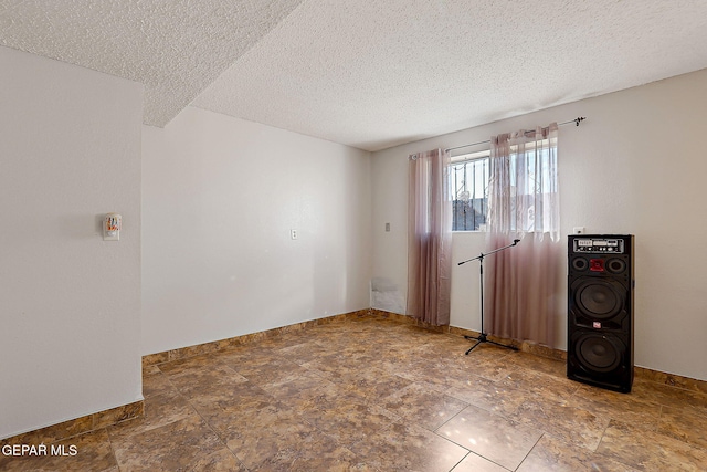 3705 Roslyn Dr, Horizon City, TX 79928 - spare room featuring a textured ceiling, baseboards, and stone finish flooring