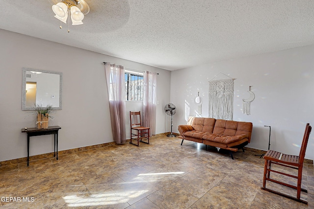 3705 Roslyn Dr, Horizon City, TX 79928 - living room featuring ceiling fan, a textured ceiling, baseboards, and stone finish floor