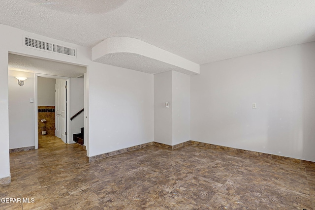 3705 Roslyn Dr, Horizon City, TX 79928 - empty room with a textured ceiling, baseboards, stone finish floor, and visible vents
