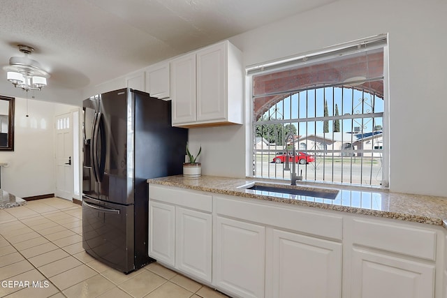 3705 Roslyn Dr, Horizon City, TX 79928 - kitchen with freestanding refrigerator, a ceiling fan, light tile patterned floors, a sink, and white cabinets