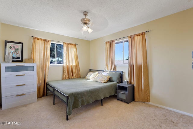 3705 Roslyn Dr, Horizon City, TX 79928 - bedroom featuring multiple windows, light carpet, ceiling fan, and a textured ceiling