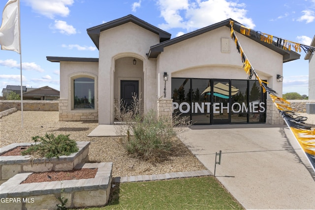 view of front of home featuring an attached garage, driveway, stucco siding, and fence