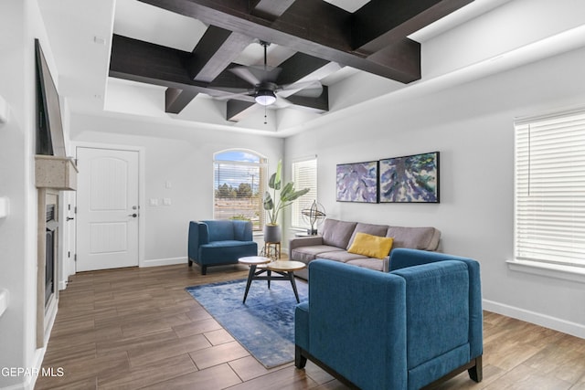 living area with coffered ceiling, wood finished floors, ceiling fan, and baseboards
