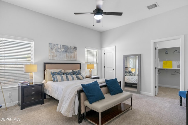 bedroom with visible vents, baseboards, a ceiling fan, and light carpet