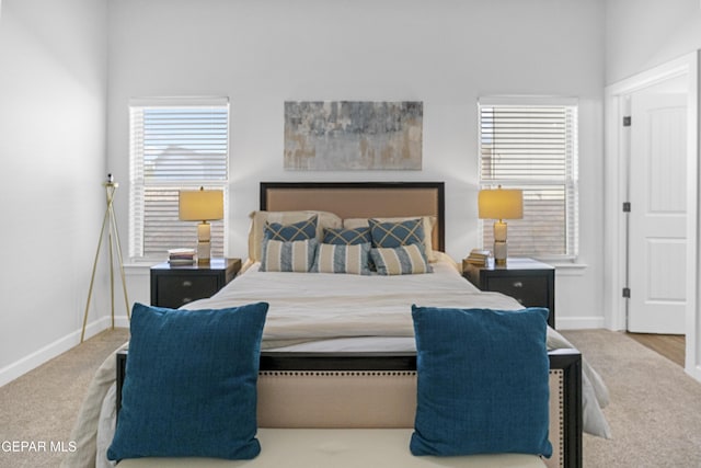 bedroom with baseboards, multiple windows, and carpet flooring
