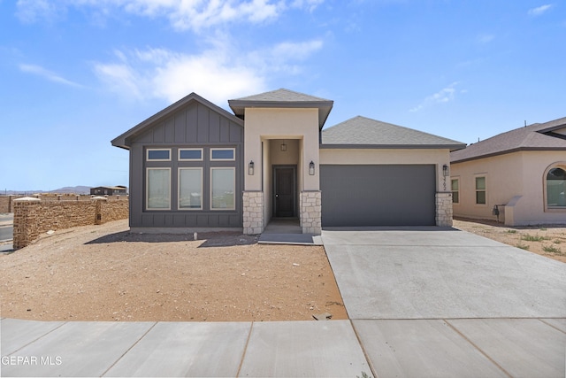 3792 Surmise St, El Paso, TX 79938 - view of front facade with an attached garage, board and batten siding, concrete driveway, stone siding, and roof with shingles