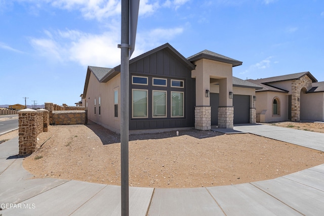 3792 Surmise St, El Paso, TX 79938 - view of front of property featuring an attached garage, concrete driveway, board and batten siding, and stone siding