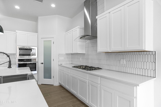 3792 Surmise St, El Paso, TX 79938 - kitchen featuring stainless steel appliances, wall chimney range hood, light countertops, backsplash, and recessed lighting