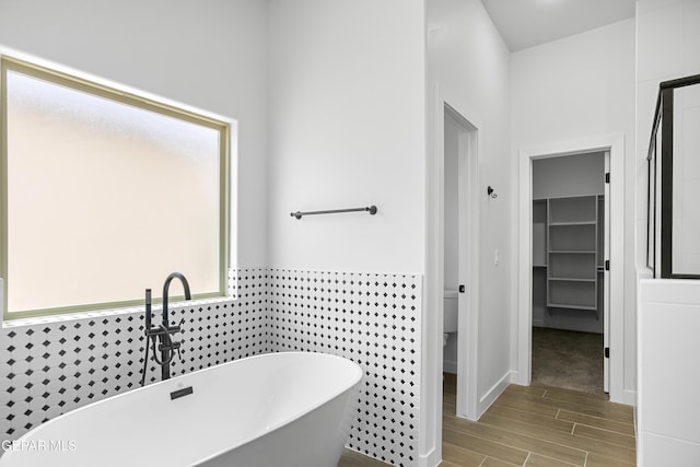 3792 Surmise St, El Paso, TX 79938 - bathroom with a soaking tub, wood finished floors, a spacious closet, a sink, and toilet