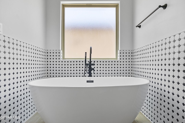 3792 Surmise St, El Paso, TX 79938 - bathroom with tile walls, a freestanding bath, and wainscoting
