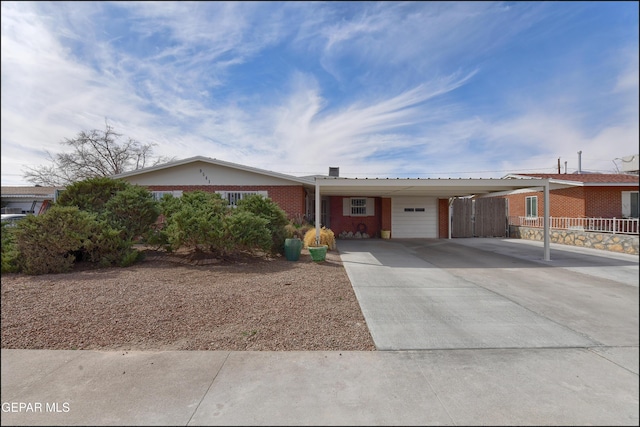 single story home with a carport, fence, brick siding, a garage, and driveway