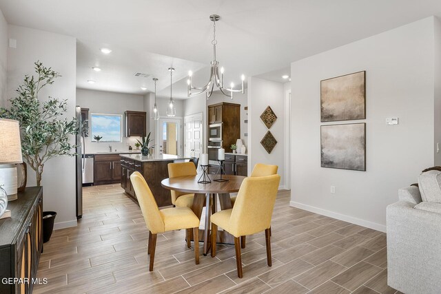 dining space with light wood-style flooring, visible vents, recessed lighting, a chandelier, and baseboards