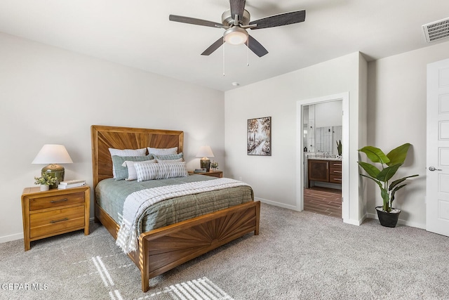 bedroom with ensuite bath, visible vents, baseboards, and light colored carpet