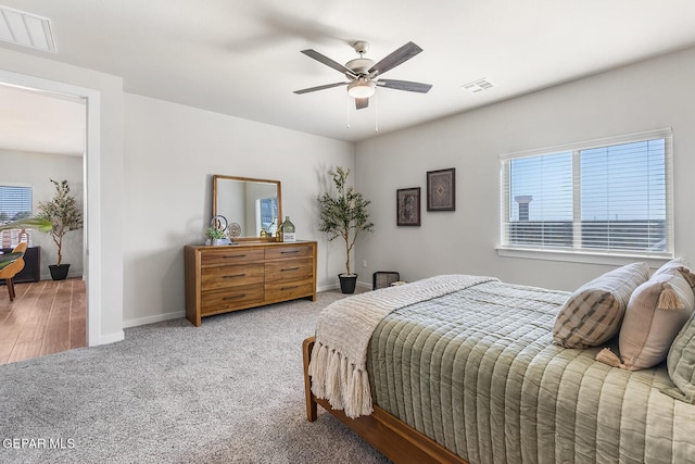 bedroom featuring carpet, visible vents, multiple windows, and baseboards