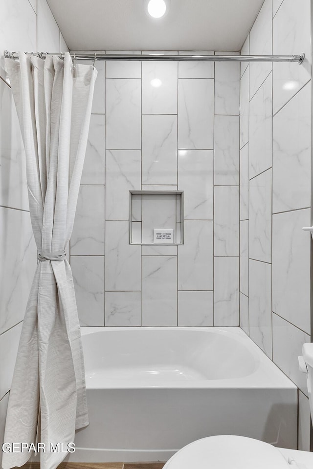 bathroom featuring toilet and shower / bath combo