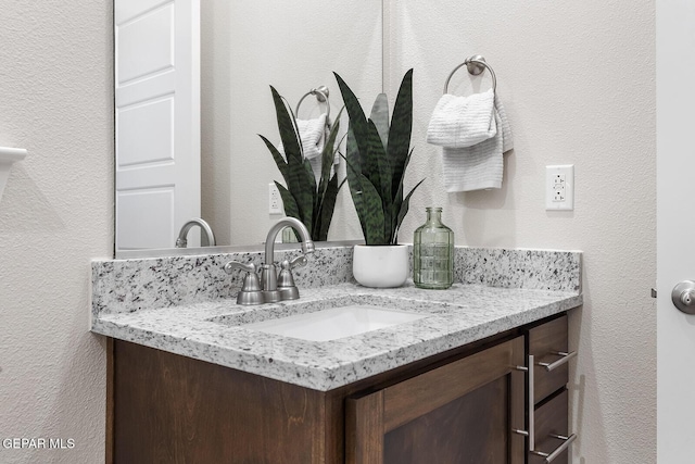 bathroom with vanity and a textured wall