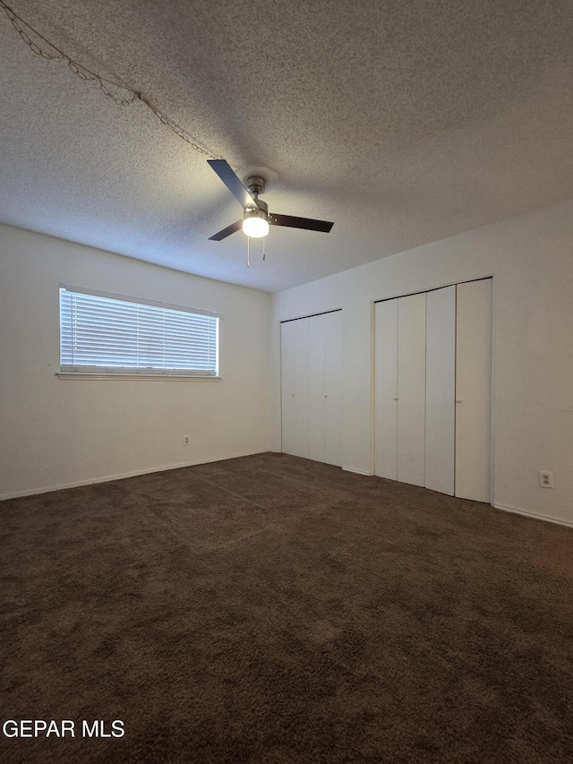 425 Irondale Dr Unit E, El Paso, TX 79912 - unfurnished bedroom with multiple closets, carpet, ceiling fan, and a textured ceiling