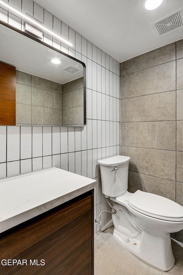 4108 Metetuye Ln, El Paso, TX 79902 - bathroom featuring toilet, vanity, visible vents, and tile walls