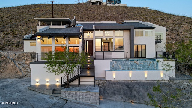 4108 Metetuye Ln, El Paso, TX 79902 - rear view of property featuring stucco siding, stairway, a shingled roof, a balcony, and a mountain view