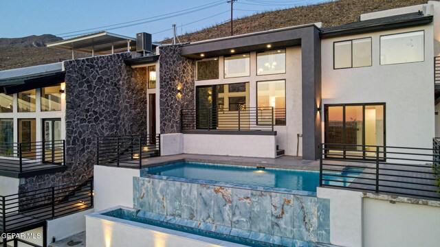 4108 Metetuye Ln, El Paso, TX 79902 - rear view of property with an outdoor pool, stucco siding, and stone siding