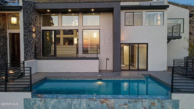 4108 Metetuye Ln, El Paso, TX 79902 - back of house featuring an outdoor pool, a patio area, stucco siding, and a balcony