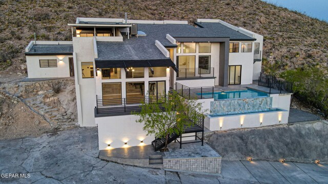 4108 Metetuye Ln, El Paso, TX 79902 - back of house featuring a patio area, a balcony, stucco siding, and an outdoor pool