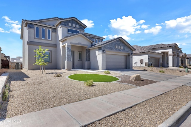 traditional home featuring a tiled roof, a garage, stucco siding, concrete driveway, and central AC unit