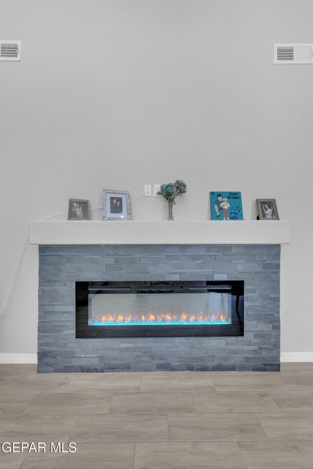 room details featuring visible vents, baseboards, and a stone fireplace