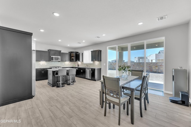 dining room with light wood-type flooring, visible vents, and recessed lighting