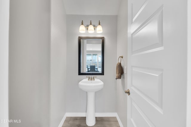 bathroom with baseboards and wood finished floors