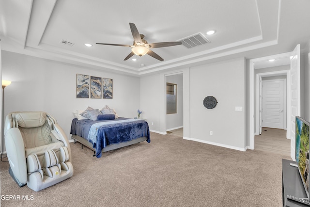 carpeted bedroom featuring visible vents, baseboards, a raised ceiling, and recessed lighting