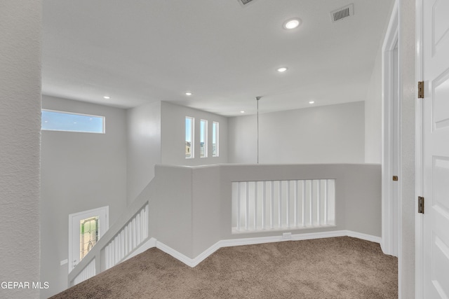 spare room featuring plenty of natural light, visible vents, carpet, and recessed lighting