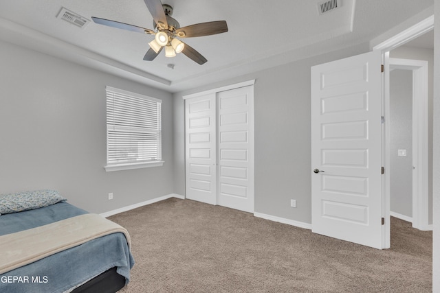 carpeted bedroom featuring visible vents, a closet, and baseboards