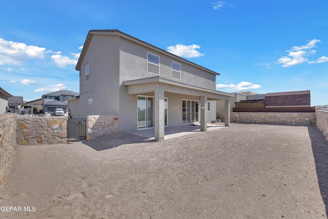 back of house with a patio area, stucco siding, and a fenced backyard