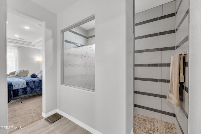 bathroom featuring a walk in shower, connected bathroom, recessed lighting, wood finished floors, and baseboards
