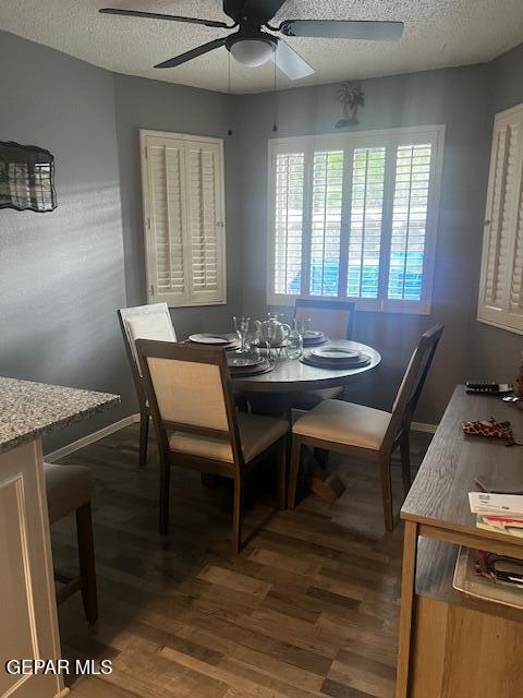 dining room featuring ceiling fan, dark wood-style flooring, and a textured ceiling