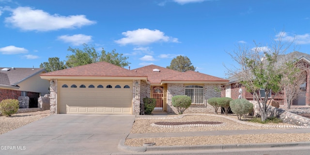 7341 Desierto Rojo Ct, El Paso, TX 79912 - ranch-style home with concrete driveway, an attached garage, and brick siding