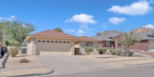 7341 Desierto Rojo Ct, El Paso, TX 79912 - ranch-style home featuring a gate, concrete driveway, cooling unit, a garage, and brick siding