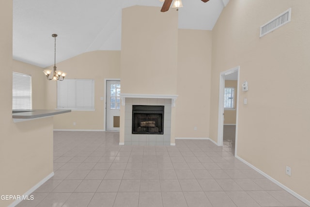 7341 Desierto Rojo Ct, El Paso, TX 79912 - unfurnished living room with ceiling fan with notable chandelier, a tiled fireplace, visible vents, and high vaulted ceiling